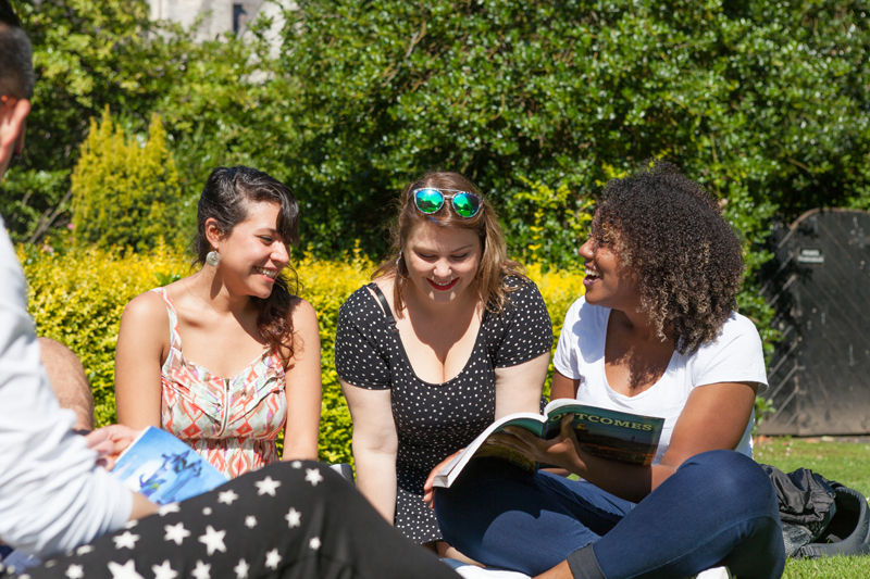 Three female students practicing english pronunciation in a garden in Dublin
