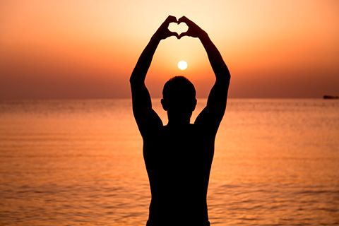 International student doing Yoga at sunset on a beach in Malta