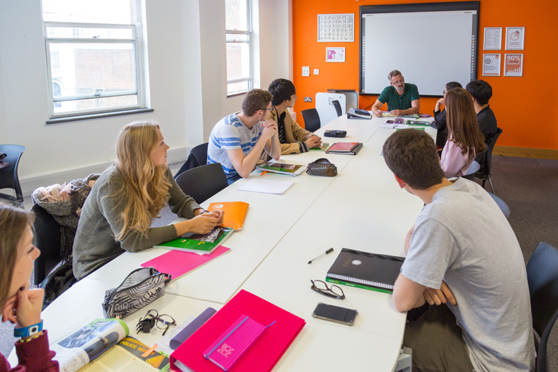 English language school in Brighton inside a classroom where a teacher talks to his students and help them improve their English language
