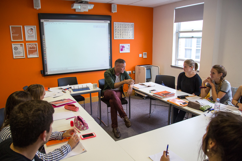 Students learning English in Brighton at EC having a chat with their teacher