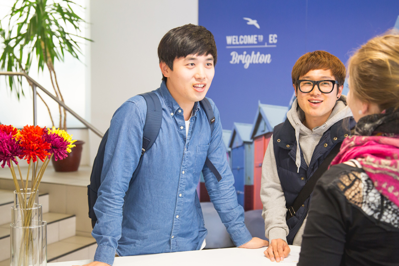 International students speaking to the receptionist at EC English school in Brighton