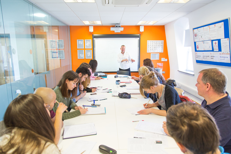 EC Language School in Brighton, with students exchanging ideas and discussing the solutions to their English language exercises with the teacher