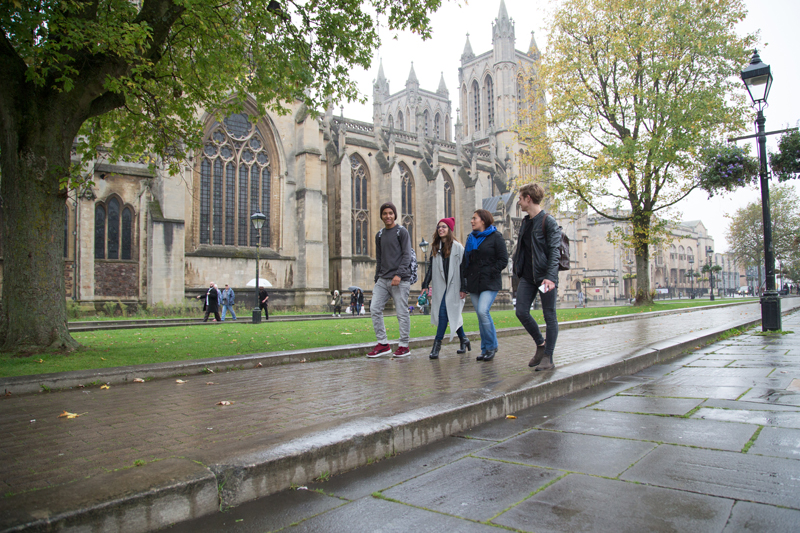 Students taking an English course at EC bristol walking outside near a Gothic cathedral