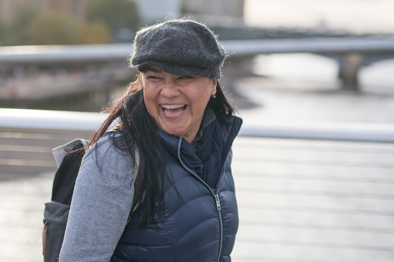Smiley student while crossing a bridge in London and go to EC London 30+