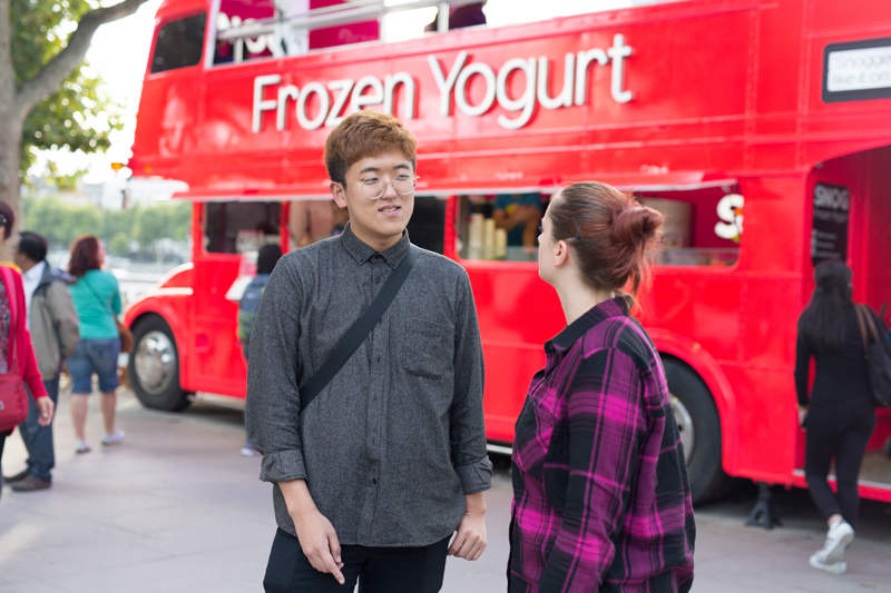 Students practicing their English in London near a Double Decker Bus selling Frozen Yogurt