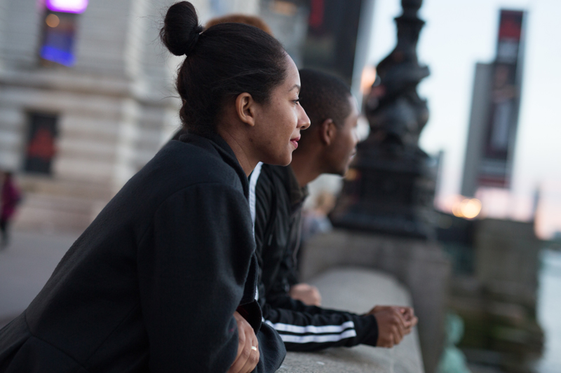 Happy students learning English in London gazing over a bridge in their free time on a lovely serene evening