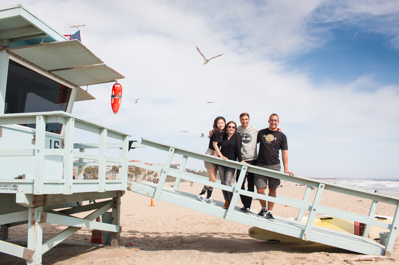 EC English students learning English in Los Angeles, posing on the life-guard lookout on the beach on a sunny day